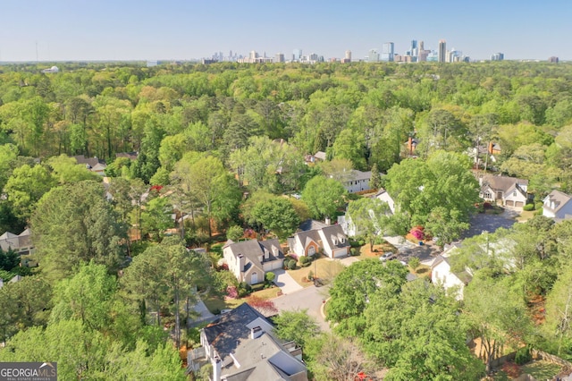 aerial view of property and surrounding area with a forest and a skyline view