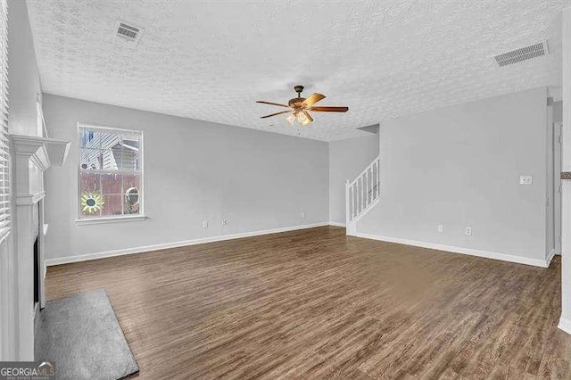 unfurnished living room featuring a fireplace with flush hearth, wood finished floors, a ceiling fan, and visible vents