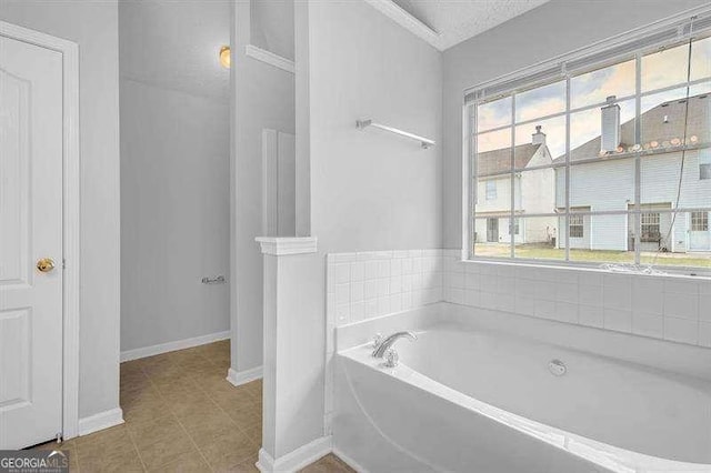 bathroom featuring tile patterned floors, a bath, and baseboards
