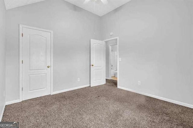 unfurnished bedroom with carpet floors, baseboards, high vaulted ceiling, and ceiling fan