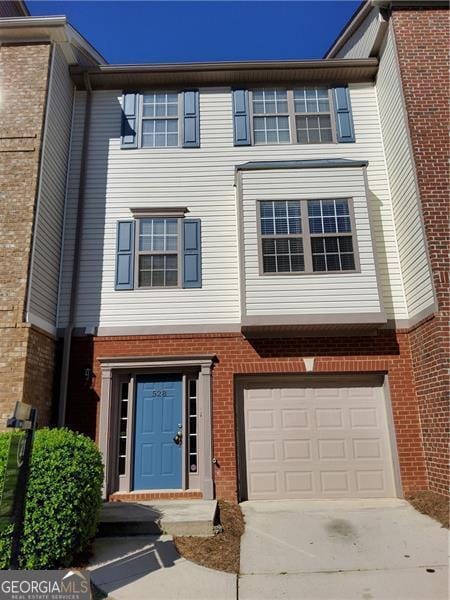 view of property with an attached garage, brick siding, and driveway