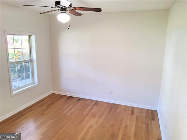empty room featuring light wood-style flooring, baseboards, and a ceiling fan
