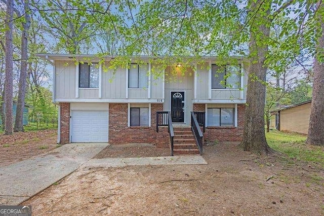 split foyer home featuring an attached garage, driveway, and brick siding