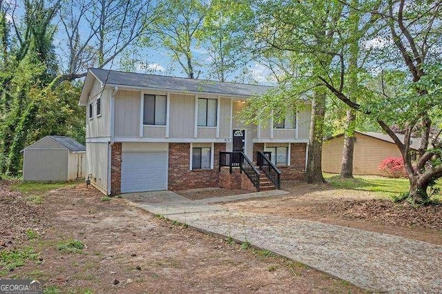 raised ranch featuring an outbuilding, a garage, a storage shed, brick siding, and driveway