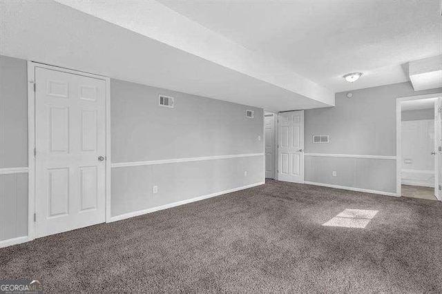 unfurnished room featuring visible vents, baseboards, carpet, and a textured ceiling