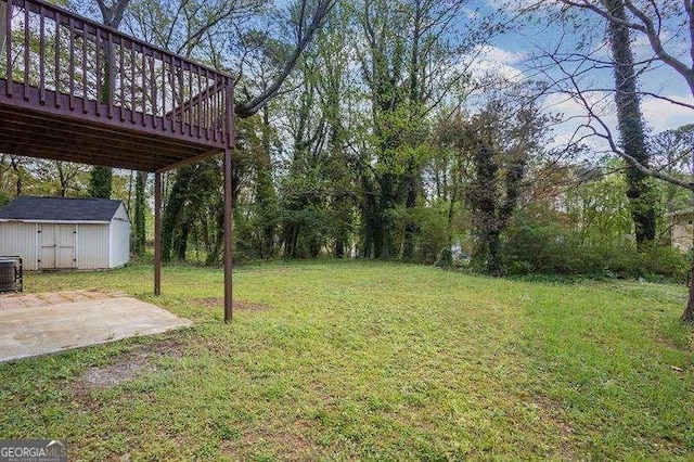 view of yard with a shed, a patio area, an outdoor structure, cooling unit, and a wooden deck
