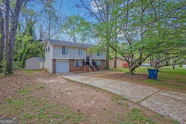 bi-level home with an outbuilding, an attached garage, concrete driveway, a storage unit, and brick siding