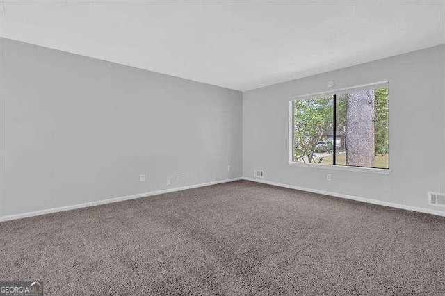 carpeted empty room featuring baseboards