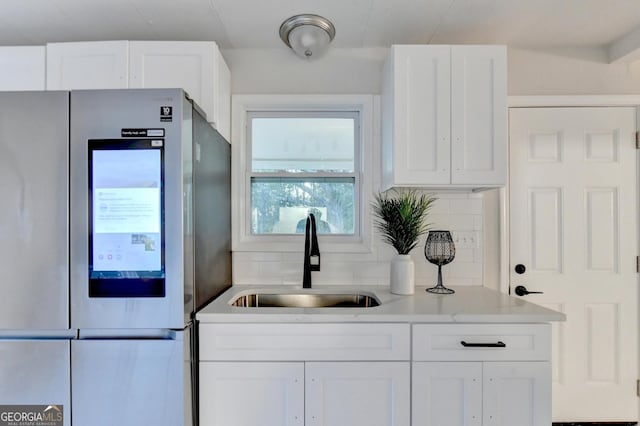 21 W Lake Dr, Oxford, GA 30054 - kitchen with backsplash, white cabinetry, a sink, and refrigerator with glass door