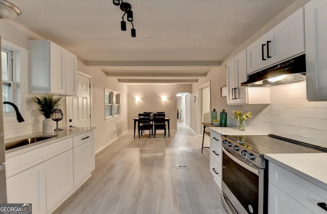 21 W Lake Dr, Oxford, GA 30054 - kitchen featuring light countertops, stainless steel range with electric stovetop, under cabinet range hood, beamed ceiling, and a sink