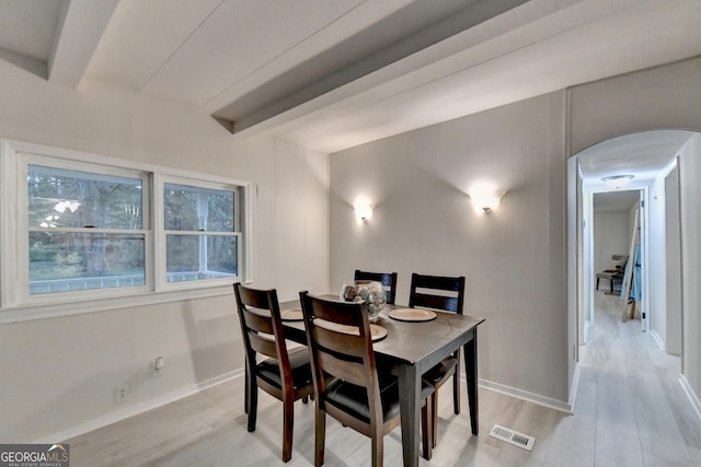 21 W Lake Dr, Oxford, GA 30054 - dining room with light wood-style flooring, arched walkways, visible vents, baseboards, and beam ceiling