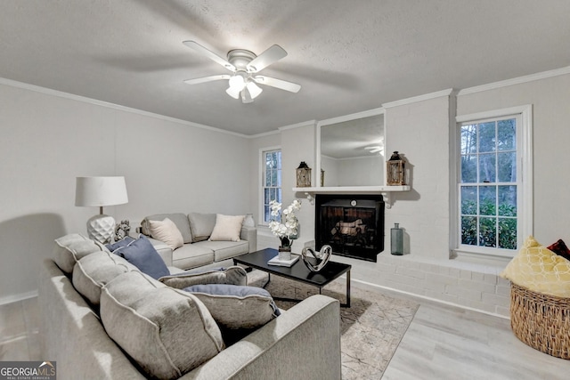 21 W Lake Dr, Oxford, GA 30054 - living room with a brick fireplace, ornamental molding, ceiling fan, a textured ceiling, and wood finished floors