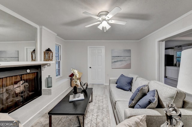 21 W Lake Dr, Oxford, GA 30054 - living area featuring baseboards, a fireplace with raised hearth, ornamental molding, ceiling fan, and wood finished floors