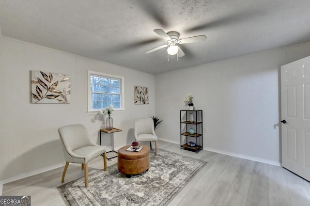 21 W Lake Dr, Oxford, GA 30054 - sitting room with light wood-style flooring, a textured ceiling, baseboards, and a ceiling fan