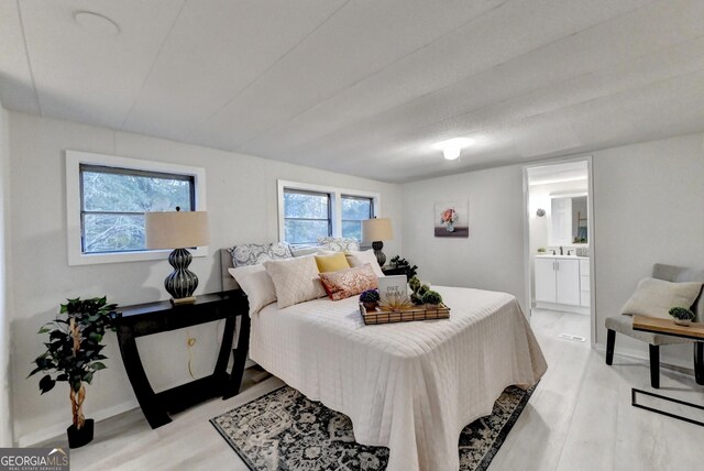 21 W Lake Dr, Oxford, GA 30054 - bedroom with light wood-style floors, ensuite bathroom, and baseboards