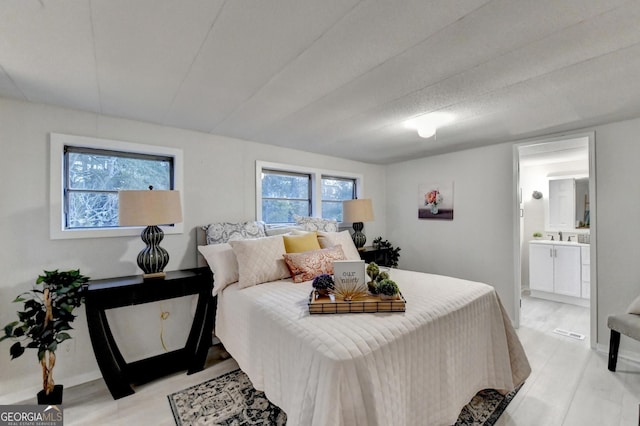 21 W Lake Dr, Oxford, GA 30054 - bedroom with light wood-style floors, visible vents, and connected bathroom