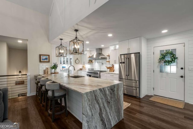 6477 Old Shadburn Ferry Rd, Buford, GA 30518 - kitchen featuring appliances with stainless steel finishes, wall chimney range hood, a sink, a peninsula, and a kitchen bar