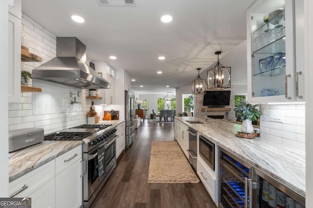 6477 Old Shadburn Ferry Rd, Buford, GA 30518 - kitchen with island exhaust hood, appliances with stainless steel finishes, white cabinets, wine cooler, and recessed lighting