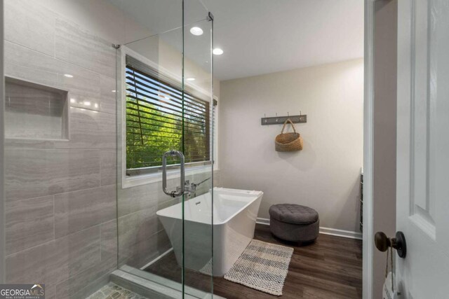 6477 Old Shadburn Ferry Rd, Buford, GA 30518 - bathroom with a soaking tub, recessed lighting, wood finished floors, and baseboards