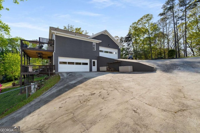 6477 Old Shadburn Ferry Rd, Buford, GA 30518 - view of home's exterior with stucco siding, fence, driveway, and a wooden deck