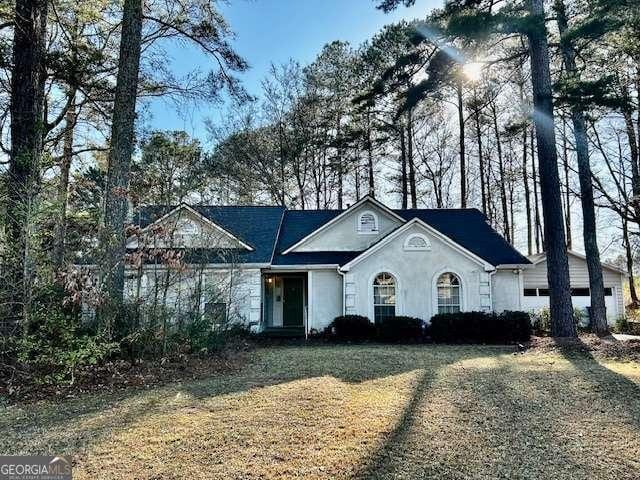 view of front of house with a front lawn and stucco siding