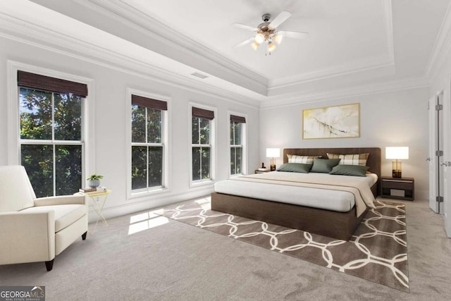carpeted bedroom featuring crown molding, visible vents, ceiling fan, and a raised ceiling