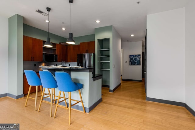 747 Ralph Mcgill Blvd NE Unit 223, Atlanta, GA 30312 - kitchen featuring black microwave, a breakfast bar area, baseboards, refrigerator with ice dispenser, and light wood-style flooring