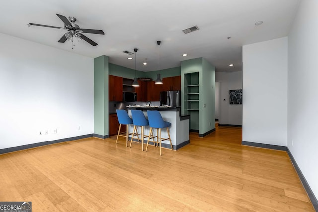 747 Ralph Mcgill Blvd NE Unit 223, Atlanta, GA 30312 - kitchen featuring freestanding refrigerator, a kitchen breakfast bar, light wood-type flooring, baseboards, and dark countertops