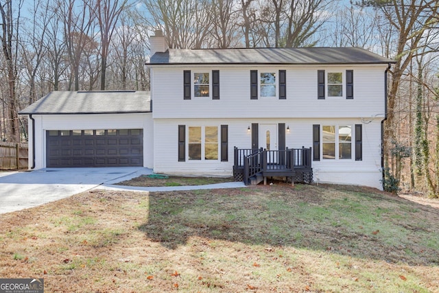 5465 N Fork Dr SW, Lilburn, GA 30047 - colonial home with an attached garage, a chimney, fence, concrete driveway, and a front lawn
