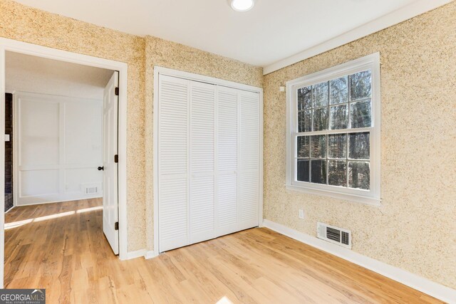 5465 N Fork Dr SW, Lilburn, GA 30047 - unfurnished bedroom with visible vents, a closet, and wood finished floors