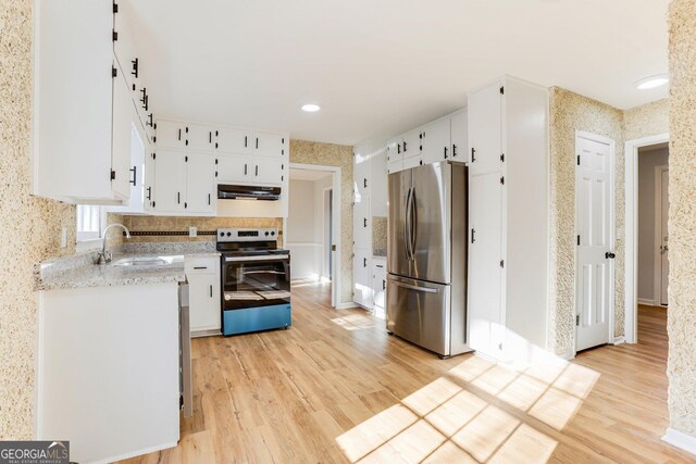 5465 N Fork Dr SW, Lilburn, GA 30047 - kitchen featuring white cabinets, a sink, light wood-type flooring, appliances with stainless steel finishes, and under cabinet range hood