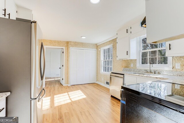 5465 N Fork Dr SW, Lilburn, GA 30047 - kitchen with a healthy amount of sunlight, freestanding refrigerator, a sink, and dishwashing machine