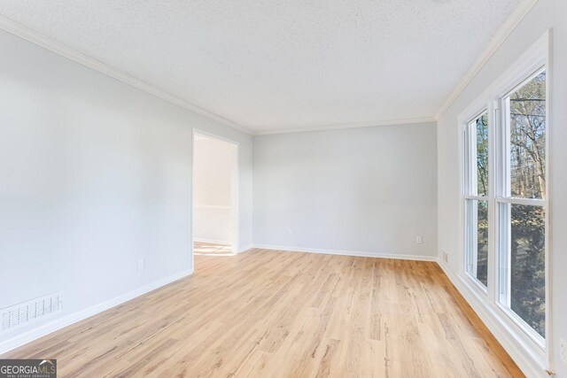 5465 N Fork Dr SW, Lilburn, GA 30047 - unfurnished room with light wood-style flooring, a textured ceiling, ornamental molding, and visible vents
