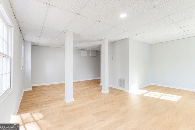 5465 N Fork Dr SW, Lilburn, GA 30047 - below grade area featuring light wood-style floors, a paneled ceiling, visible vents, and a wealth of natural light