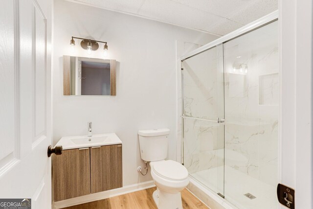 5465 N Fork Dr SW, Lilburn, GA 30047 - bathroom featuring vanity, toilet, wood finished floors, a marble finish shower, and baseboards