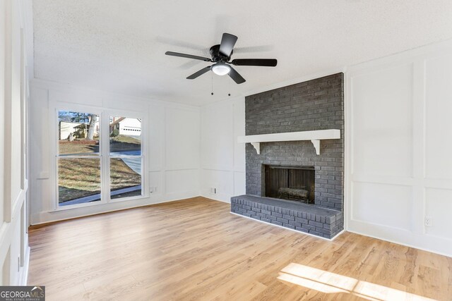 5465 N Fork Dr SW, Lilburn, GA 30047 - unfurnished living room featuring a decorative wall, ceiling fan, wood finished floors, and a textured ceiling