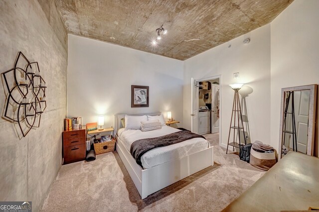 bedroom featuring a spacious closet, washer / dryer, and carpet floors