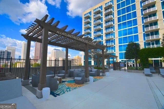 view of patio with fence, a view of city, and a pergola