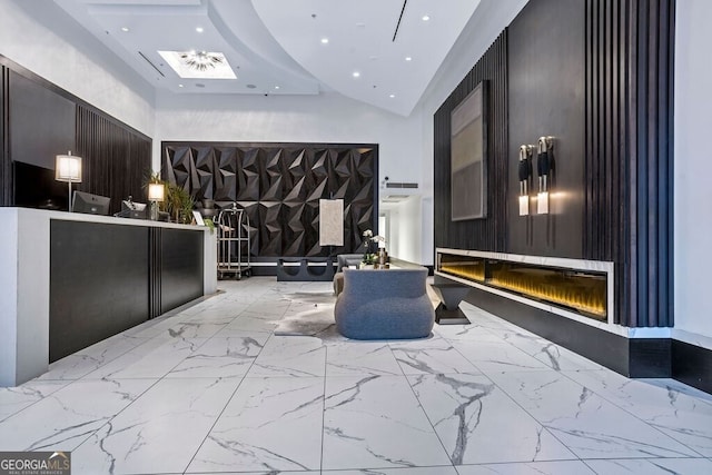 welcome area featuring a glass covered fireplace
