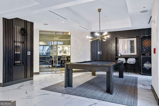 recreation room with a tray ceiling, billiards, marble finish floor, and a chandelier