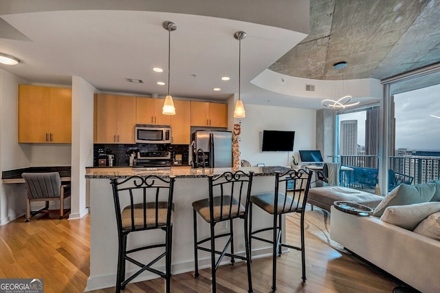 kitchen with open floor plan, light wood finished floors, visible vents, and stainless steel appliances