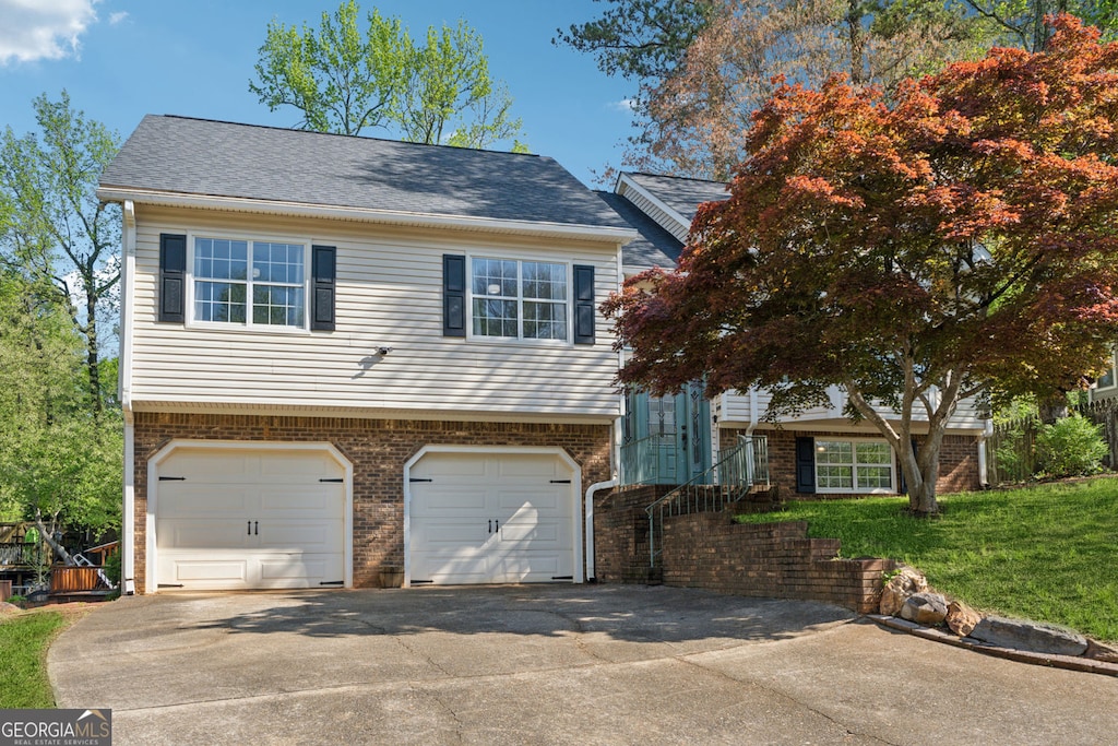 view of front of property with concrete driveway, brick siding, and an attached garage