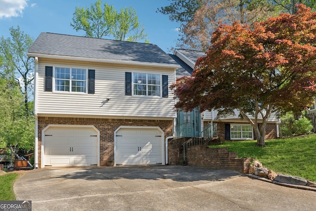 view of front of property with concrete driveway, brick siding, and an attached garage