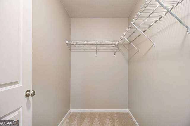 empty room with baseboards, light carpet, a raised ceiling, visible vents, and ceiling fan