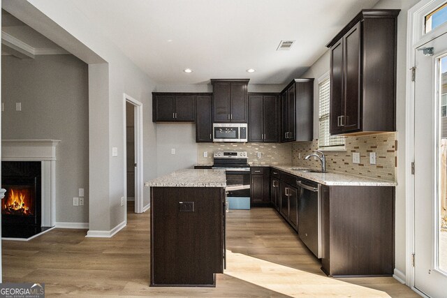 unfurnished living room with light wood-style flooring, decorative columns, and baseboards