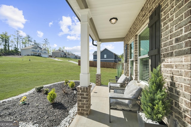 view of patio featuring fence, a porch, and a residential view