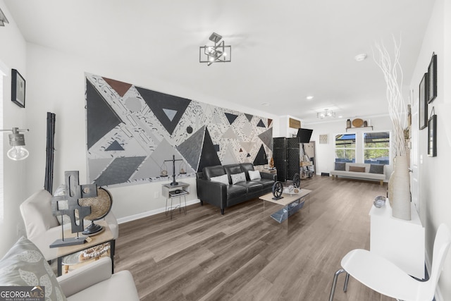living room with recessed lighting, an accent wall, wood finished floors, and baseboards