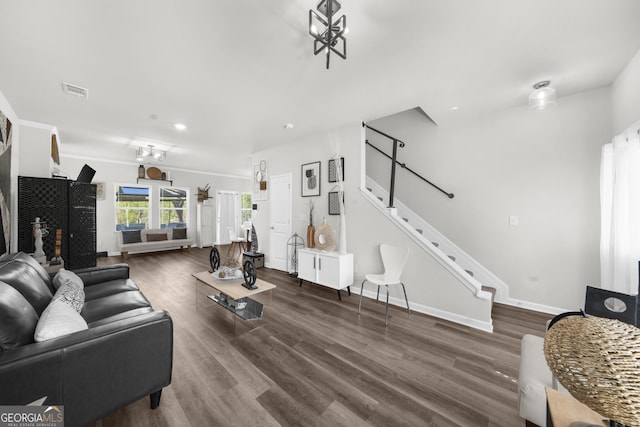 living area with stairway, wood finished floors, visible vents, and baseboards