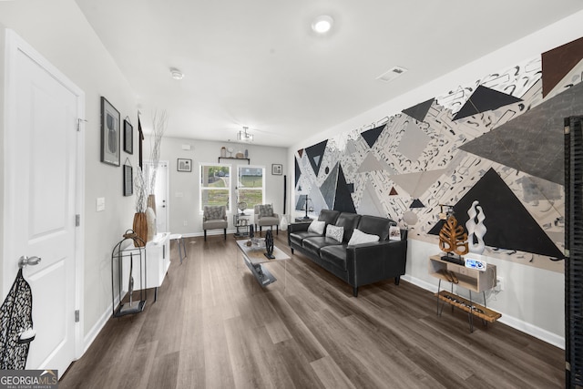 living area with wood finished floors, visible vents, and baseboards