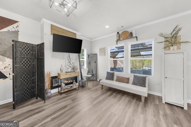 living area with crown molding, visible vents, wood finished floors, and baseboards